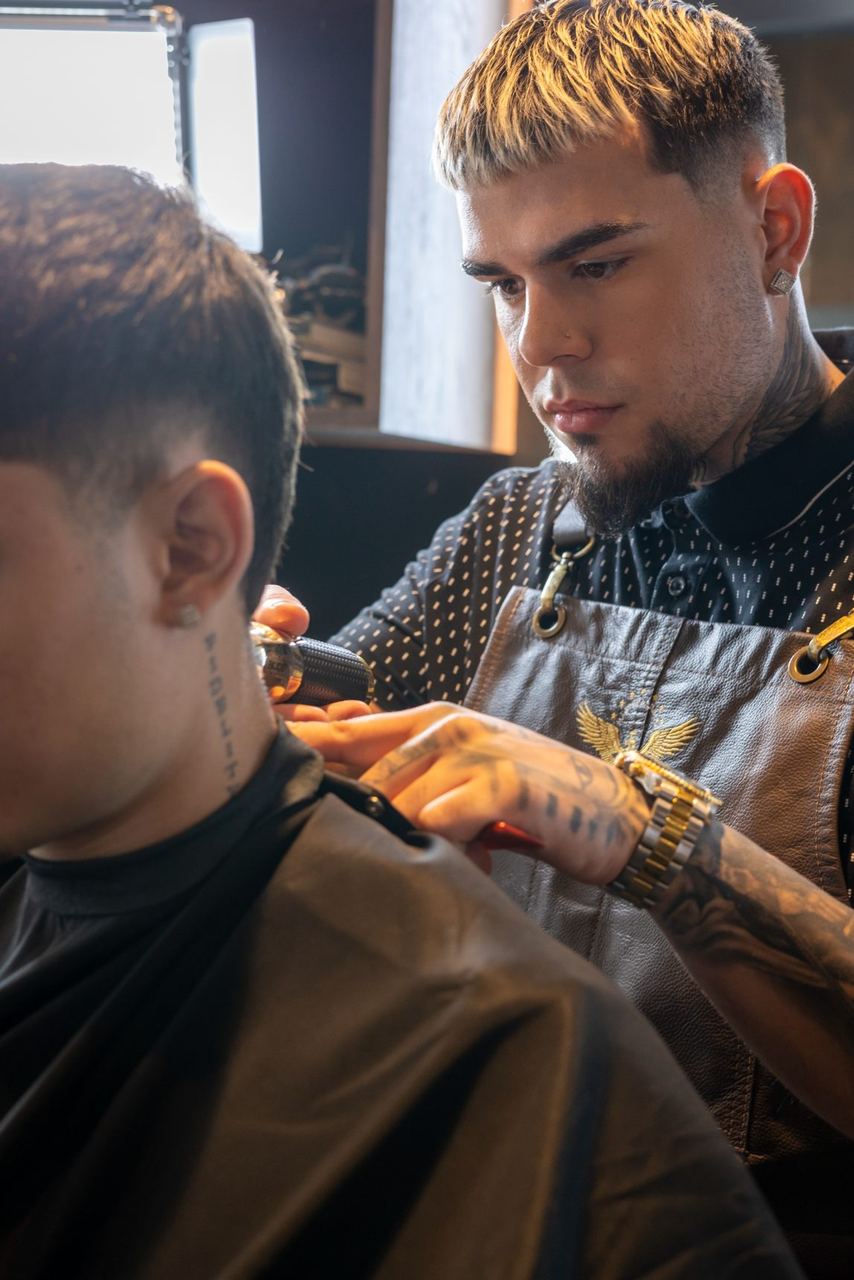 Barber in a Shaving District apron cleaning up a neckline