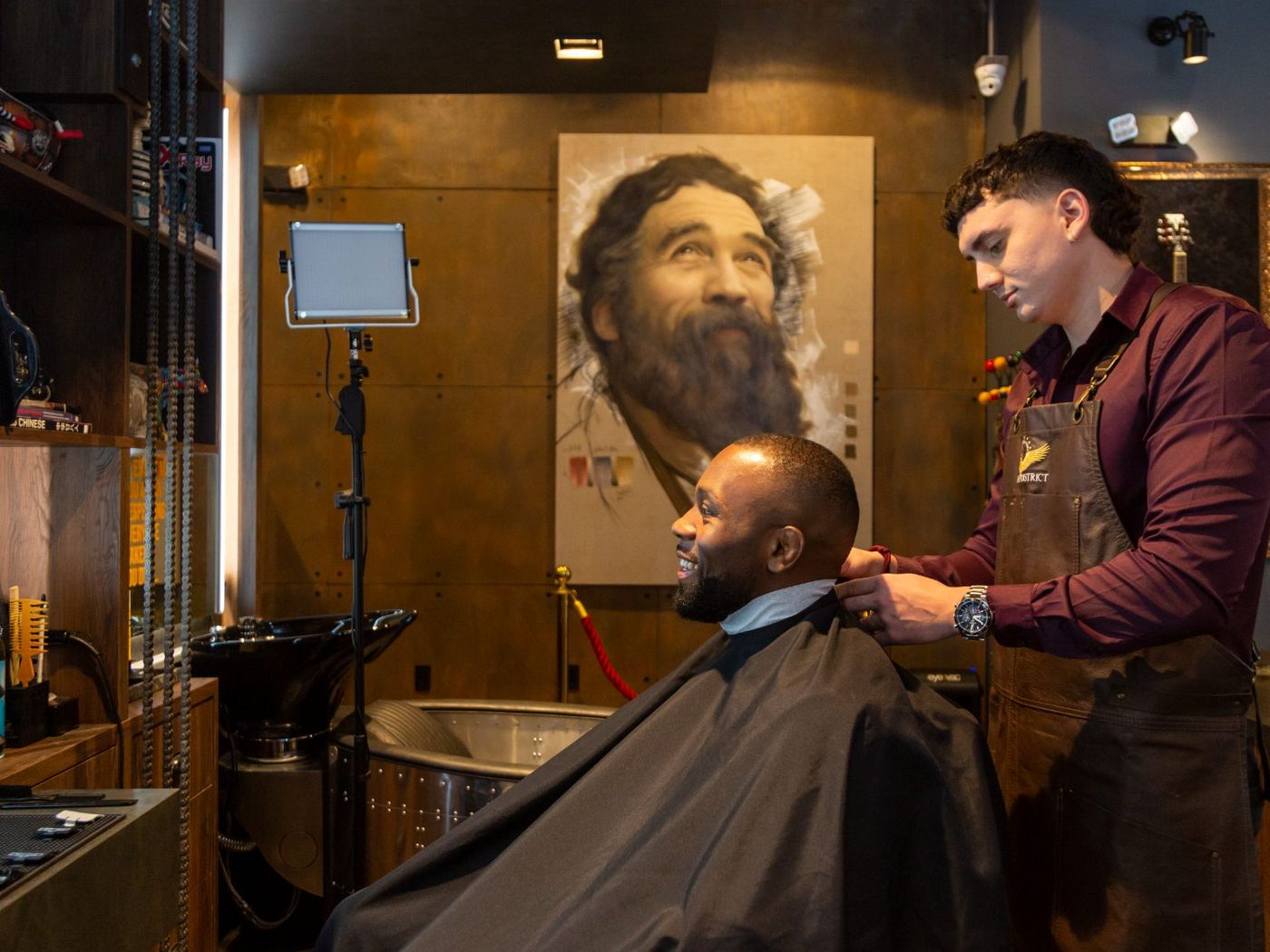 Barber finishing a cut on the Shaving District floor