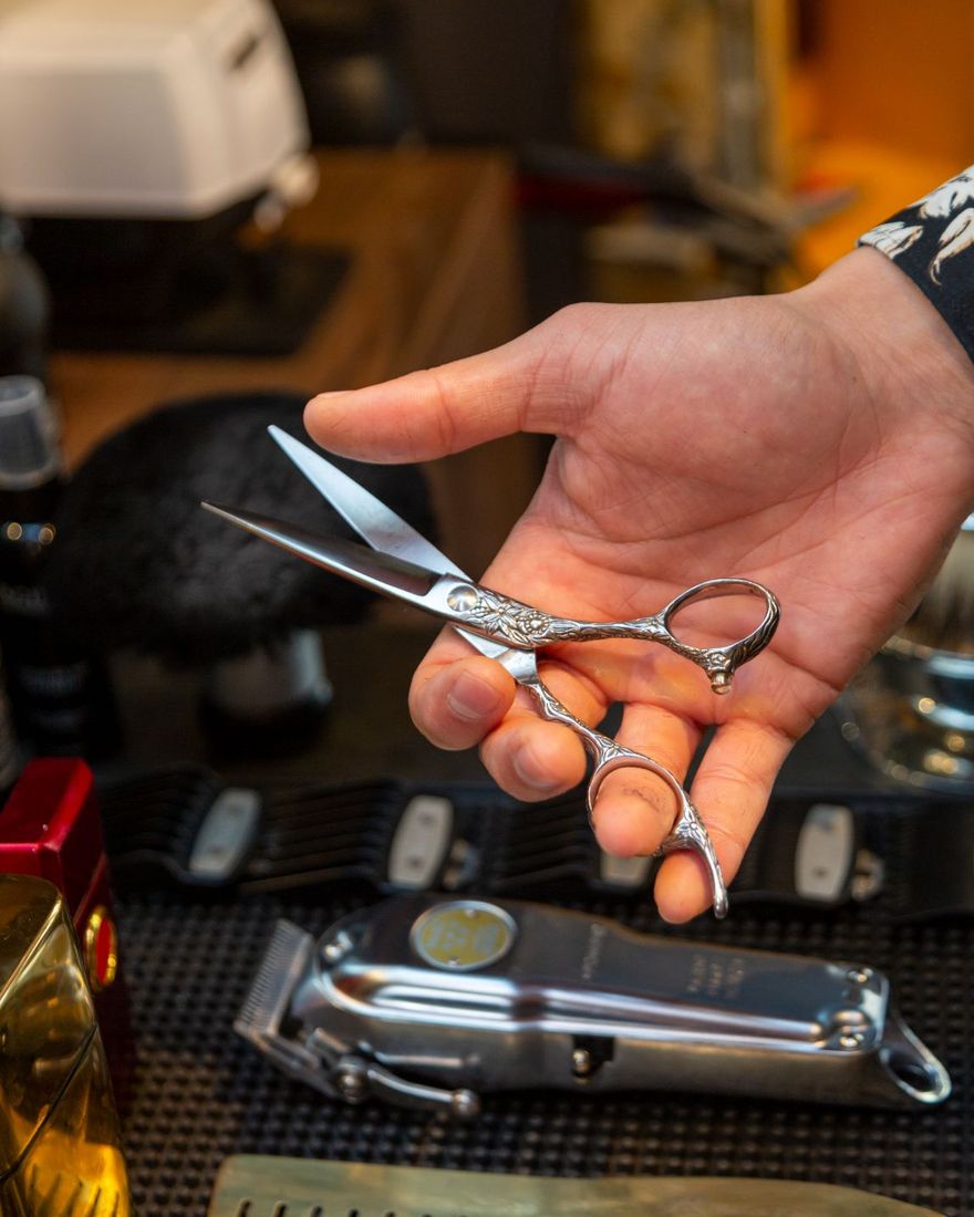 Barber&rsquo;s scissors in hand
